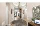 A welcoming foyer features an elegant chandelier, neutral walls, and a view into the home's interior design at 31108 N 122Nd Ln, Peoria, AZ 85383