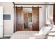 Main bedroom featuring a barn door leading to the en-suite bathroom with a soaking tub and shower at 31108 N 122Nd Ln, Peoria, AZ 85383