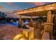 A gorgeous outdoor kitchen and covered patio area includes built-in barbecue and bar with views of the pool and desert landscape at 31108 N 122Nd Ln, Peoria, AZ 85383
