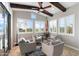 Sunroom with ample windows providing natural light, comfortable seating arrangement, and tile flooring at 31108 N 122Nd Ln, Peoria, AZ 85383