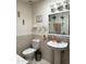 Bathroom features a tile surround, toilet, pedestal sink, and mirrored medicine cabinet with light fixture at 3231 N 81St Pl, Scottsdale, AZ 85251