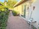 Back patio with sliding glass door, small table, brick surface, and mature landscaping at 3231 N 81St Pl, Scottsdale, AZ 85251