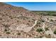 Desert homesite with paved road winding up to a custom luxury residence in the background at 3284 W Highlands Dr, Buckeye, AZ 85396
