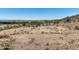 Expansive desert lot with views of nearby homes, vegetation, and rolling hills in the distance at 3284 W Highlands Dr, Buckeye, AZ 85396
