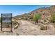 Desert homesite with a sign showing the lot details and dirt path at 3284 W Highlands Dr, Buckeye, AZ 85396
