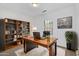 Home office with a modern desk, bookshelf, a leather chair, and natural light at 33731 N Bowles Dr, San Tan Valley, AZ 85144
