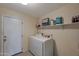 Laundry room with a washer and dryer next to a white door at 350 E Huber St, Mesa, AZ 85201