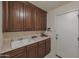 Laundry room showcasing wooden cabinets and a white sink at 350 E Huber St, Mesa, AZ 85201