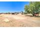 Desert property featuring a home with a large concrete pad and a detached storage shed at 35019 N Central Ave, Phoenix, AZ 85086