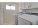 Bright laundry room featuring a white washer and dryer, cabinets, and a window at 35019 N Central Ave, Phoenix, AZ 85086