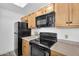 Functional kitchen with black appliances, wood cabinets, and plenty of countertop space at 3830 E Lakewood E Pkwy # 2126, Phoenix, AZ 85048