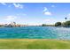 Scenic lake view featuring waterfront properties, swaying palm trees, and calm water reflecting the clear blue sky at 3830 E Lakewood E Pkwy # 2126, Phoenix, AZ 85048