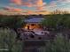 Aerial view of home with desert landscaping, rock feature, and outdoor seating on covered patio at 40123 N Majesty Trl, Anthem, AZ 85086