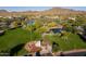 Aerial view of neighborhood park featuring lush green spaces, a pond and flower garden at 40123 N Majesty Trl, Anthem, AZ 85086