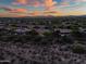 Distant aerial view of desert landscape dotted with homes featuring Spanish tile roofs and solar panels at 40123 N Majesty Trl, Anthem, AZ 85086