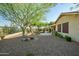 A charming backyard featuring decorative gravel, a mature tree, and a stone waterfall feature at 40123 N Majesty Trl, Anthem, AZ 85086