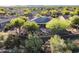 Aerial view of a private backyard with lush landscaping, desert scape, water feature, and solar panels on the roof at 40123 N Majesty Trl, Anthem, AZ 85086