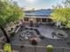 Landscaped backyard with large stone patio, rock feature, solar panels, and wrought iron fence at 40123 N Majesty Trl, Anthem, AZ 85086