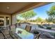 A covered patio featuring a table and chairs overlooks the landscaped backyard and rock water feature at 40123 N Majesty Trl, Anthem, AZ 85086