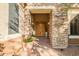 Covered entryway features stone accents with a double-door entrance and potted plants at 40123 N Majesty Trl, Anthem, AZ 85086