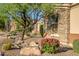 Beautiful single-story home with desert landscaping, stone accents, and mature trees in front yard at 40123 N Majesty Trl, Anthem, AZ 85086