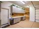 Spacious garage with gray cabinets, workbench, and epoxy flooring at 40123 N Majesty Trl, Anthem, AZ 85086