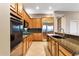 Bright kitchen showcasing natural wood cabinetry, granite counters, stainless appliances, and tile flooring at 40123 N Majesty Trl, Anthem, AZ 85086