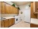 Bright laundry room features tile flooring, front load washer and dryer, and ample cabinet space at 40123 N Majesty Trl, Anthem, AZ 85086