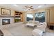 Cozy living room featuring a fireplace, built-in shelving, large windows offering scenic views and neutral tones at 40123 N Majesty Trl, Anthem, AZ 85086