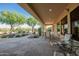 Cozy covered patio area with seating overlooking the lush backyard and desert landscape at 40123 N Majesty Trl, Anthem, AZ 85086