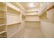 Large walk-in closet with neutral carpet, shelving, and ample storage space at 40123 N Majesty Trl, Anthem, AZ 85086