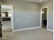 Spacious bedroom with neutral colors, carpet flooring, and doorways leading to the kitchen and bathroom at 4079 E Roosevelt St, Apache Junction, AZ 85119