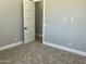 Bedroom with gray walls and carpet and white trim, showing open door to a connecting room at 4079 E Roosevelt St, Apache Junction, AZ 85119