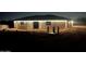Exterior view of a newly constructed house at night, featuring stone accents and illuminated soffits at 4079 E Roosevelt St, Apache Junction, AZ 85119