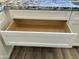 An open, empty kitchen drawer showcasing the custom, bright white cabinetry and modern finishes at 4079 E Roosevelt St, Apache Junction, AZ 85119