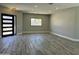 Open living room with modern lighting, wood floors, and black framed window and door at 4079 E Roosevelt St, Apache Junction, AZ 85119