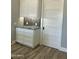 Butler's pantry with gray backsplash, granite countertops, white cabinetry, and wide plank flooring at 4079 E Roosevelt St, Apache Junction, AZ 85119