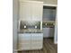Bright butler's pantry with white cabinets, gray backsplash, granite countertops, and wide plank flooring at 4079 E Roosevelt St, Apache Junction, AZ 85119