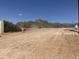 View of unpaved road with surrounding desert landscape and mountains in the background at 4079 E Roosevelt St, Apache Junction, AZ 85119