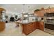 Open concept kitchen featuring a breakfast bar with granite countertops, stainless appliances, and cozy living space at 4245 E Ficus Way, Gilbert, AZ 85298