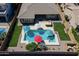Gorgeous aerial view of a backyard featuring a sparkling pool, spa, lush landscaping, and ample patio space at 4266 E Blue Sage Ct, Gilbert, AZ 85297