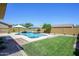 Expansive backyard featuring a pool, lush green lawn, and a built-in BBQ area, perfect for outdoor living at 4266 E Blue Sage Ct, Gilbert, AZ 85297