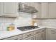 Kitchen showcasing stainless steel range hood, subway tile backsplash, and a modern gas cooktop at 4266 E Blue Sage Ct, Gilbert, AZ 85297