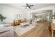 Bright living room featuring wood floors, ceiling fan, stylish furniture, and an open floor plan to the kitchen at 4266 E Blue Sage Ct, Gilbert, AZ 85297