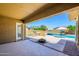 Covered patio offering a serene view of the pool and landscaped backyard, perfect for relaxation and outdoor gatherings at 4266 E Blue Sage Ct, Gilbert, AZ 85297