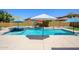Backyard pool area with umbrellas and a built-in jacuzzi, ideal for outdoor relaxation and entertainment at 4266 E Blue Sage Ct, Gilbert, AZ 85297