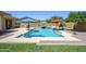 Inviting backyard pool with a water feature and shaded lounge areas, perfect for relaxing and entertaining guests at 4266 E Blue Sage Ct, Gilbert, AZ 85297