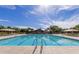 Community swimming pool featuring multiple lounge chairs and umbrellas for relaxing on a sunny day at 4266 E Blue Sage Ct, Gilbert, AZ 85297
