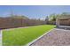 This lush backyard features low-maintenance landscaping, artificial turf, and a covered patio at 43727 W Wade Dr, Maricopa, AZ 85138