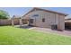 An appealing backyard offers low-maintenance artificial turf and a covered patio, perfect for effortless enjoyment at 43727 W Wade Dr, Maricopa, AZ 85138